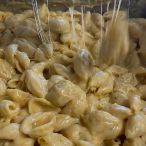 Close-up of creamy, cheesy macaroni and cheese with cheese pulls, a FATBOYSBBQ side dish.